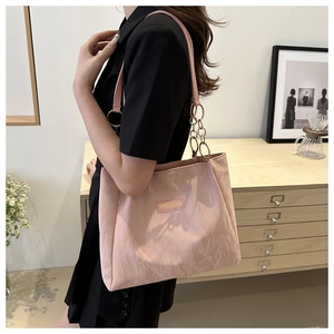 Borsa tote rosa trapuntata con catena dorata ed etichetta indossata da una modella