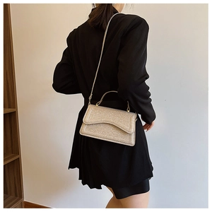 Detail of silver glitter crossbody bag with metallic shimmer and sleek rectangular flap