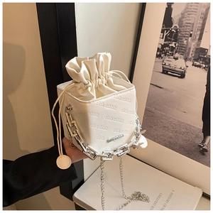 Detail of white PU leather box bag with rich rabbit embossed text and chunky silver chain
