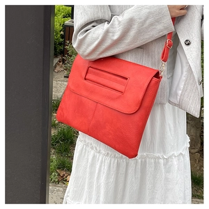 Sac enveloppe en cuir PU rouge texturé avec poignée et bandoulière en extérieur