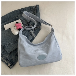 Détail du sac cabas plissé bleu clair avec pendentif en peluche et bandoulière réglable