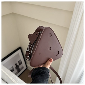 Dettaglio della borsa a tracolla marrone a forma di formaggio con design traforato