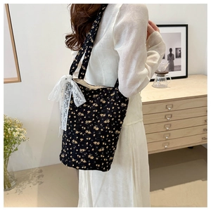 Detailed close-up of floral tote bag featuring a white lace bow and pleated fabric texture
