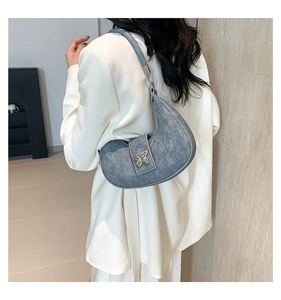 Sac sous le bras croissant gris avec boucle papillon porté à l'épaule par le mannequin