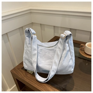 Détail du sac cabas en tissu plissé bleu clair avec boucle en métal doré réglable