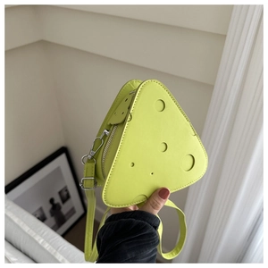 Dettaglio borsa a tracolla a triangolo verde neon a forma di formaggio con fori decorativi