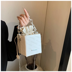 Detail of white leather box bag featuring rich rabbit embossed letters and silver chain