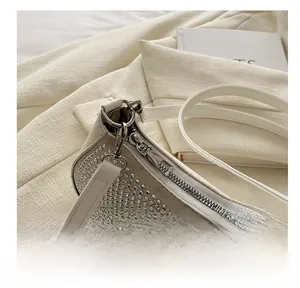 Detailed close-up of the silver rhinestone shoulder bag showing hardware hook and zipper