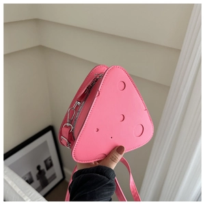 Dettaglio della borsa a triangolo rosa acceso a forma di formaggio con decori circolari