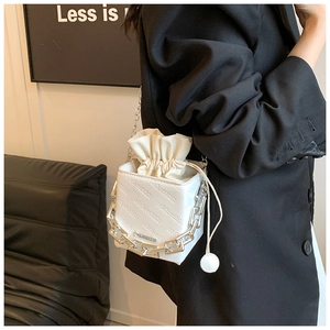Detail of white mini bucket bag with rich rabbit letter embossing and silver chain strap