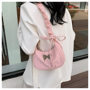 Detail of pink half-moon bag with silver butterfly metal buckle and ruffled bow strap