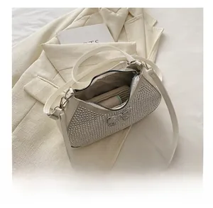 Detail view of white rhinestone shoulder bag interior capacity with metal bow