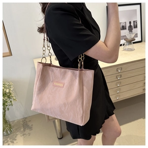 Dettaglio della borsa tote rosa con etichetta moda, trama stropicciata e catena