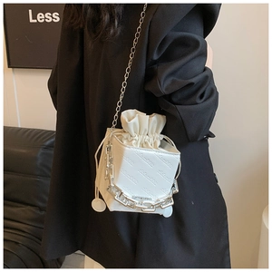 Detail of white leather crossbody bag with letter embossing and silver chain strap