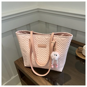 Detailed wave-patterned pink tote bag with a plush monster charm and branded leather patch
