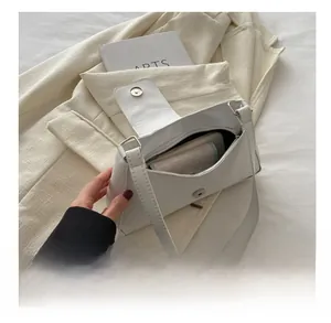 White leather underarm bag interior view showing magnetic closure and internal zipper pocket