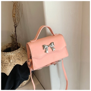 Detailed macro view of pink cross-grain leather texture and silver bow buckle on the bag