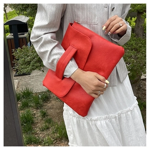 Gros plan sur un sac à main rouge grande capacité avec texture cuir et large poignée