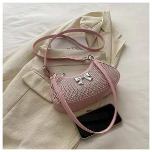 Detail of pink rhinestone crescent bag with silver bow accent and PU leather strap