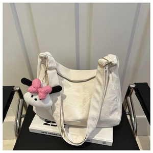 Détail de la texture plissée sur le sac Hobo blanc avec un pendentif en peluche