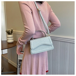 Silver glitter crossbody bag worn by a model in a stylish modern lifestyle setting