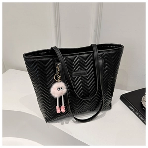 Black quilted tote bag with wave stitching, gold hardware and pink pompom charm