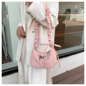 Close-up of pink hobo bag with metallic butterfly detail and ruched drawstring strap