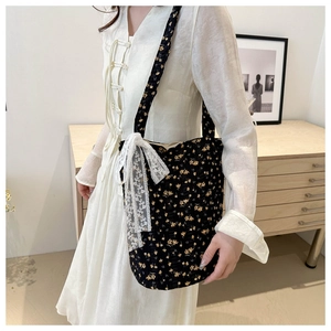 Floral fabric tote bag with lace bow detail shown on shoulder with minimalist home decor
