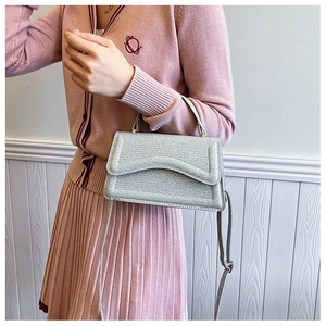 Silver glitter crossbody bag with unique wave-edge flap and golden hardware details