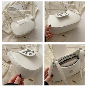 Detail view of white crescent bag showing silver bow hardware and internal zipper pocket
