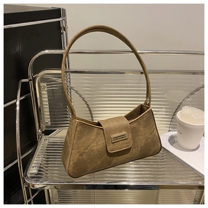 Detail of vintage brown baguette bag with matte leather texture and metal buckle clasp