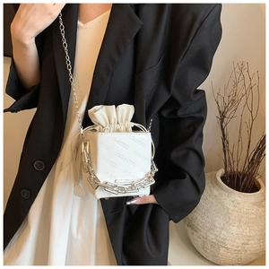 Detailed view of white bucket bag with rich rabbit embossing and chunky silver chain