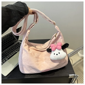 Détail du sac cabas rose clair avec surface texturée et charmant pendentif chien en peluche