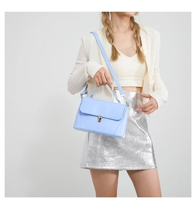Detail of light blue faux leather bag featuring silver twist lock and adjustable strap