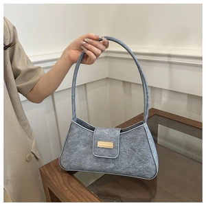 Close-up of stylish grey-blue baguette bag with matte texture and gold buckle