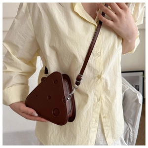 Dettaglio della borsa a tracolla creativa a forma di formaggio in pelle marrone