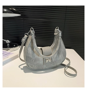 Détail du sac demi-lune gris avec fermoir papillon métallique et bandoulière réglable