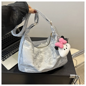 Détail du sac cabas argenté métallisé avec texture froissée et breloque peluche