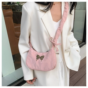 Pink pleated fabric shoulder bag with metallic butterfly and ribbon detail on strap