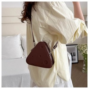 Dettaglio della mini borsa a tracolla creativa a forma di formaggio marrone con tracolla