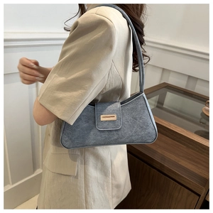 Detailed close-up of a blue baguette bag with gold buckle and frosted matte texture