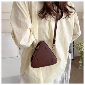 Borsa a tracolla marrone scuro a forma di formaggio con intagli indossata da modella