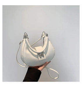 Détail du sac demi-lune blanc avec fermoir papillon argenté et poignée en cuir