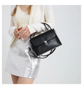 Detail view of the black flap bag with silver hardware and detachable chain strap