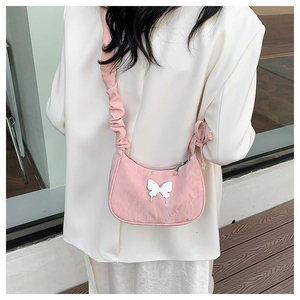 Close-up of pink shoulder bag featuring a white butterfly design and ruched strap detail
