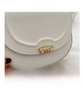Nahaufnahme der beigen Leder-Satteltasche mit einer dreistufigen goldenen Metallschnalle