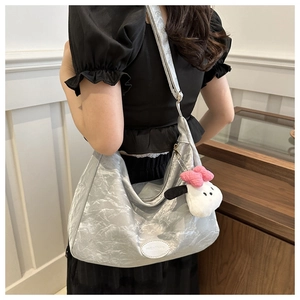 Détail du sac fourre-tout argenté plissé avec pendentif en peluche et fini métallisé