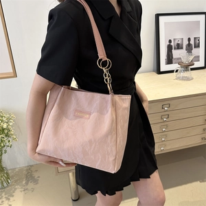 Borsa tote rosa capiente con trama plissettata e tracolla a catena dorata in scena lifestyle