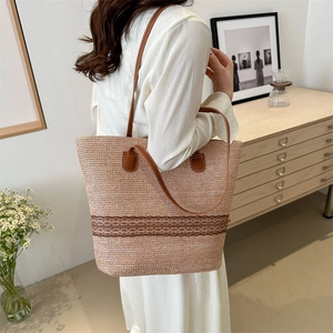 Straw tote bag with brown wavy pattern and leather straps in a home setting
