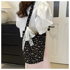 Detail of floral canvas tote bag featuring a white lace bow and yellow flower pattern